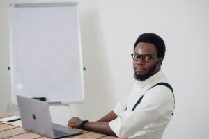 un homme assis à une table avec un ordinateur portable devant lui