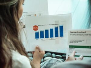 Personne analysant les graphiques financiers et les rapports de retour sur investissement, en se concentrant sur la croissance des investissements.