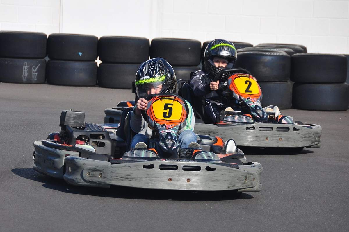 Deux jeunes pilotes dans des kartings numérotés sur piste
