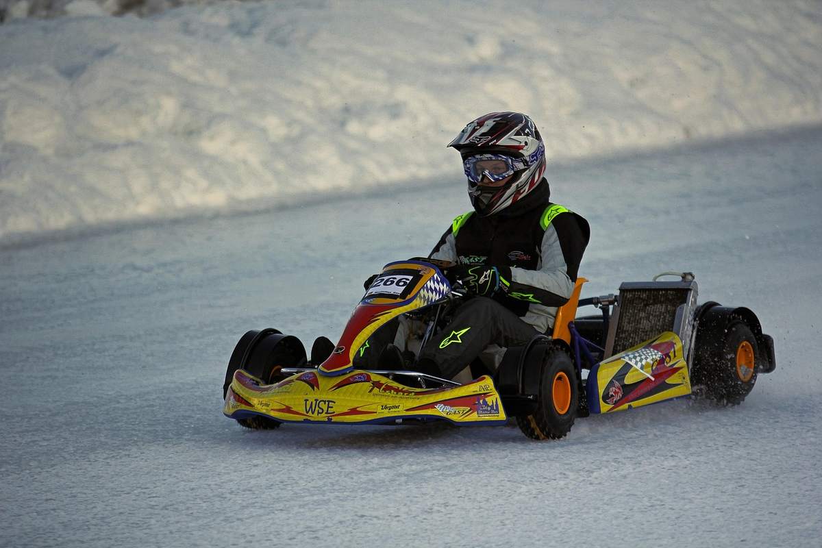 Un karting sur neige avec un pilote en casque Un karting sur neige avec un pilote en casque