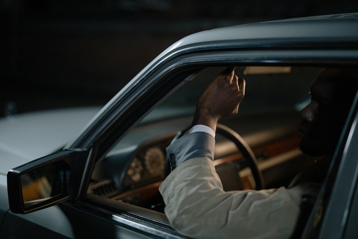 Un homme assis dans une voiture, tenant un levier à l'intérieur Un homme assis dans une voiture, tenant un levier à l'intérieur